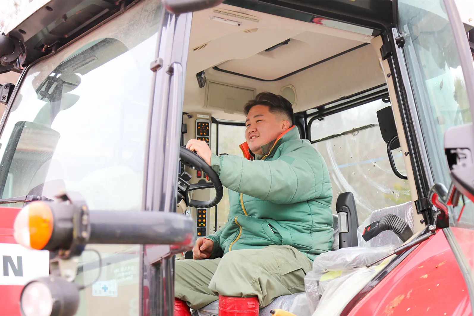 トラクターを運転する工藤さんの様子写真